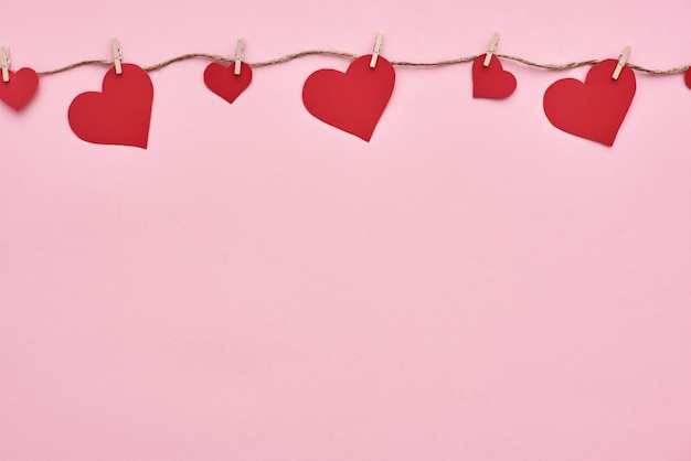 Coeurs de papier Valentine dayred accrochés à la corde à linge