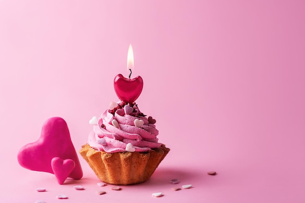 Coeurs et un petit gâteau avec bougie allumée, concept de la Saint-Valentin.