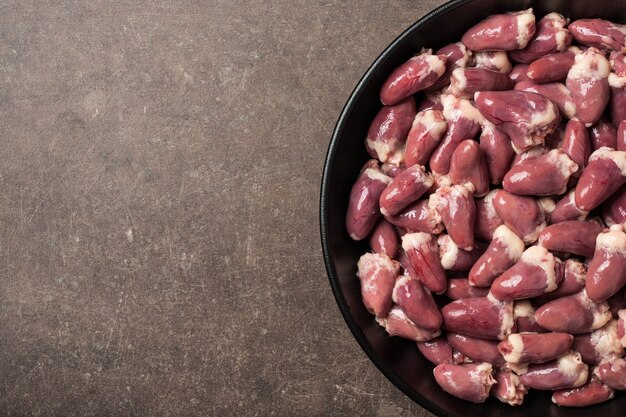 Coeurs de poulet crus dans la poêle