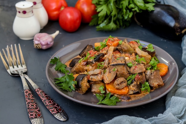 Coeurs de poulet cuits avec des légumes: carottes, aubergines, tomates, ail et oignons, pour un dîner savoureux et sain, orientation horizontale