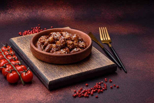 Coeurs de poulet frits dans de la sauce soja avec du sel et des épices dans une assiette