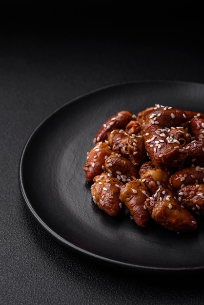 Coeurs de poulet frits dans de la sauce soja avec du sel et des épices dans une assiette