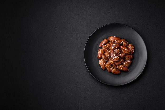 Coeurs de poulet frits dans de la sauce soja avec du sel et des épices dans une assiette