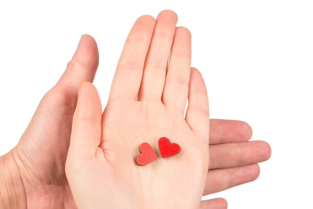 Coeurs rouges en mains de couple isolés sur blanc. Espace de copie.