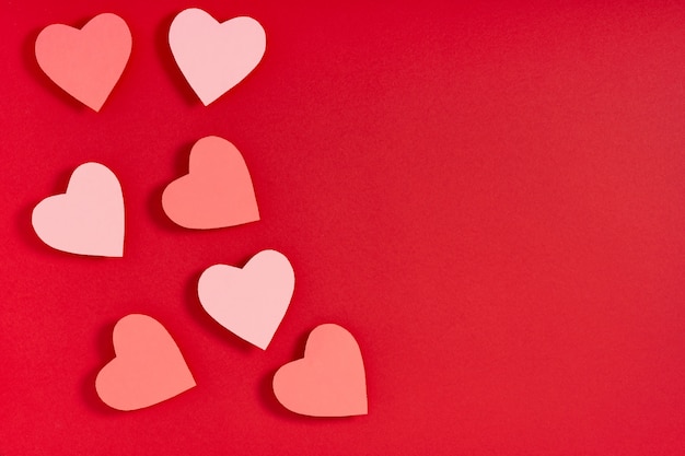 Coeurs de la Saint-Valentin sur la surface rouge. Présent, surprise, félicitations. Vue de dessus