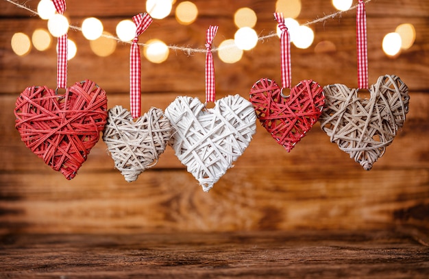 Coeurs de la Saint-Valentin suspendus à une corde sur bois.