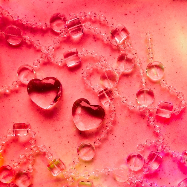 Photo coeurs transparents et perles sur marbre dans les tons roses fond de carte de voeux saint valentin parfait