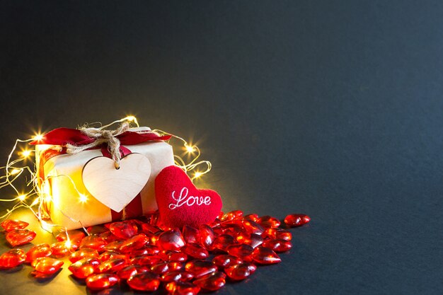 Coeurs en verre rouge et un cœur en peluche douce avec les mots Love on a black