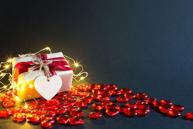 Coeurs en verre rouge et un cœur en peluche douce avec les mots Love sur un tableau noir