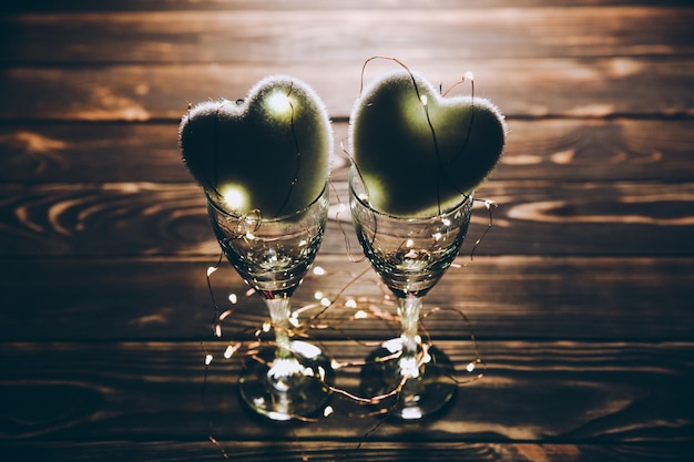 Coeurs avec des verres à vin Concept d'amour romantique Fond festif Carte postale Saint Valentin Lumières et lampes