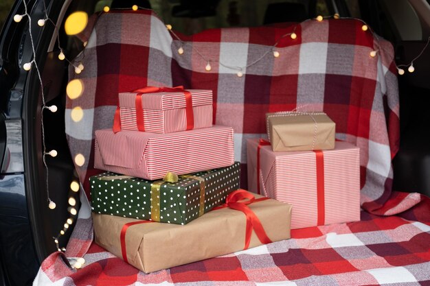 Coffre de voiture rempli de coffrets cadeaux, de cadeaux et de guirlandes pour les vacances de Noël