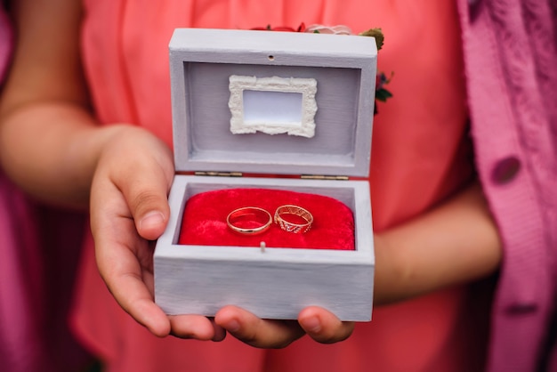 Coffret d'alliances dans les mains d'une fille pour la cérémonie de fiançailles