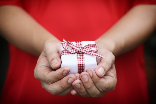 Coffret blanc sur les mains des femmes.