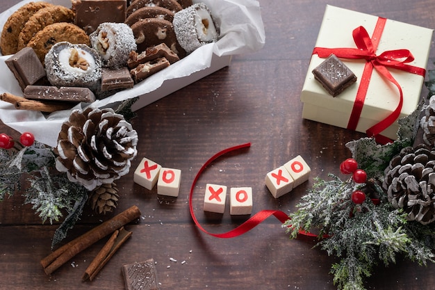 Coffret et bonbons de fête de Noël avec des décorations de saisons sur le fond en bois