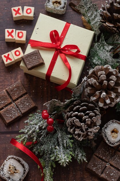 Coffret et bonbons de fête de Noël avec des décorations de saisons sur le fond en bois