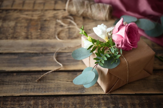 Coffret cadeau artisanal avec des fleurs sur une table en bois