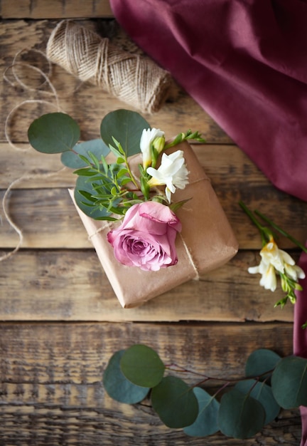 Coffret cadeau artisanal avec des fleurs sur une table en bois