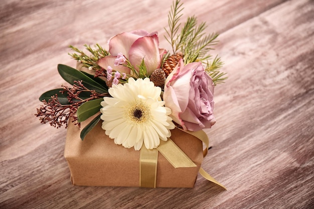 Coffret cadeau artisanal avec des fleurs sur une table en bois