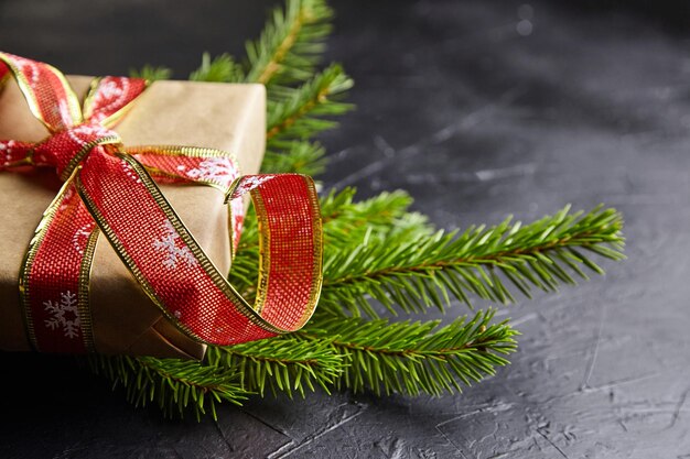 Coffret cadeau avec branche d'arbre de Noël vert sur fond sombre