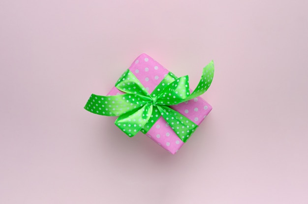 Coffret cadeau ou cadeau avec ruban vert sur rose pastel