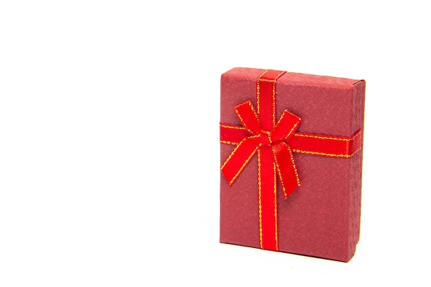 Le coffret cadeau est rouge sur fond blanc. Nouvel An et Noël, anniversaire. Cadeau. Fond blanc.