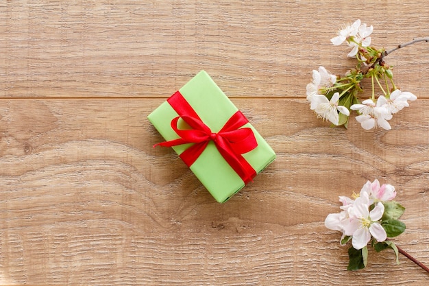 Coffret cadeau avec des fleurs de cerisier sur le fond en bois