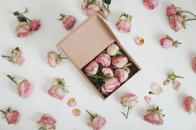 Coffret cadeau avec des fleurs roses roses sur fond blanc vue de dessus