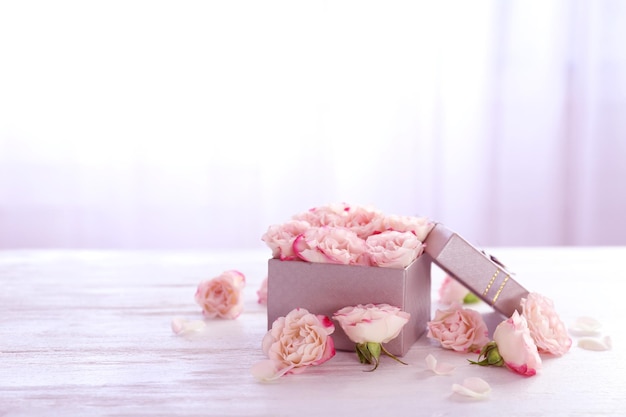 Coffret cadeau avec des fleurs sur une table en bois