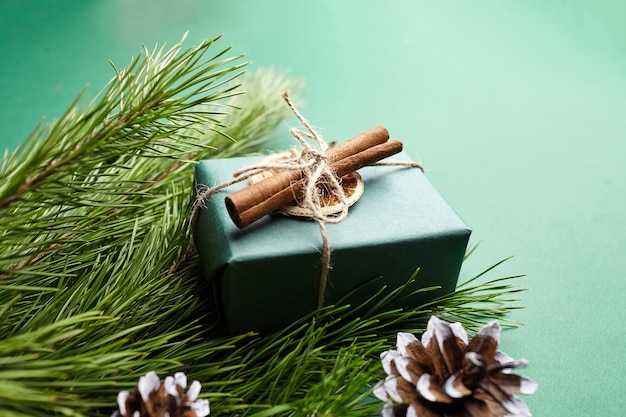 Coffret cadeau de Noël et branches de pin avec décoration sur fond vert