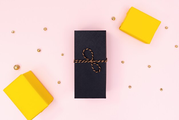 Coffret cadeau de Noël, coffret cadeau noir et jaune sur rose