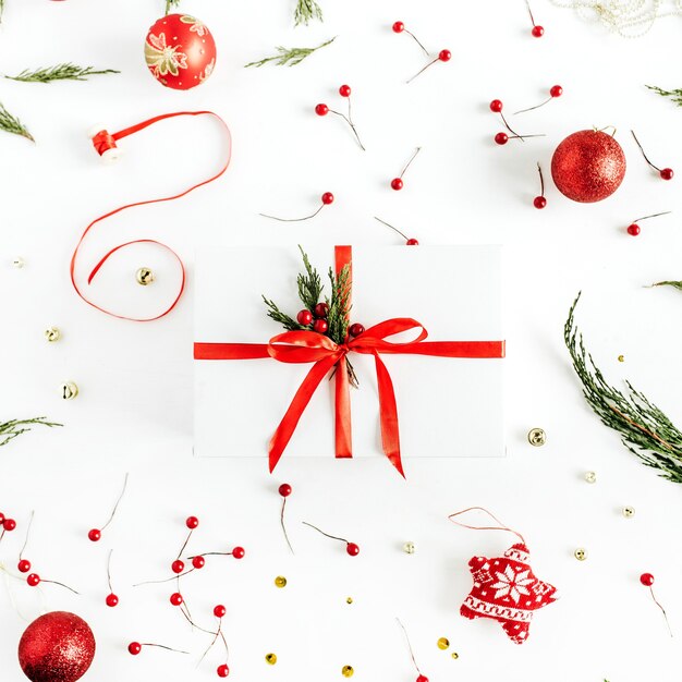 Coffret cadeau de Noël sur fond décoré de boules. Mise à plat, vue de dessus