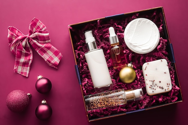 Coffret cadeau de noël vacances de noël forfait d'abonnement à la boîte de beauté et produits de soins de la peau de luxe flatlay cosmétique à plat sur fond rose cosmétiques comme cadeau de vacances ou livraison de courses