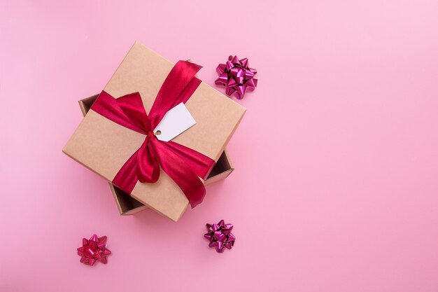 Coffret cadeau avec noeud en satin et étiquette sur fond rose