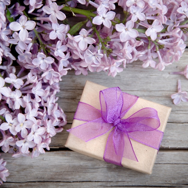 Coffret cadeau avec noeud violet et lilas sur bois