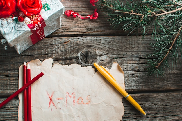 Coffret cadeau, papier marron, marron, stylo jaune sur une table en bois légende Noël et nouvel an.