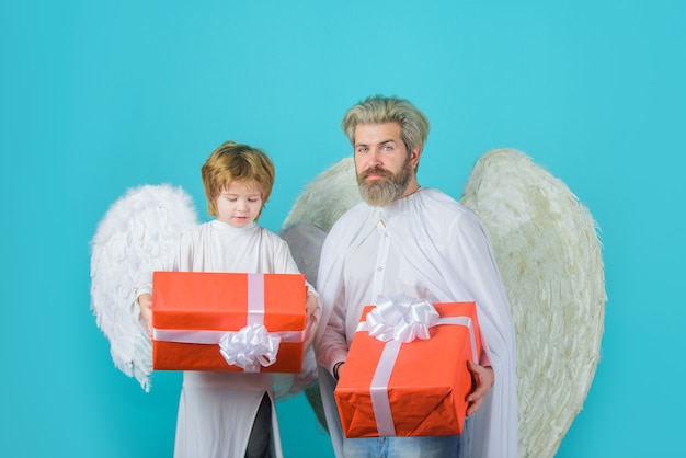 Coffret cadeau père heureux en costume d'ange avec petit fils ange détient présent ange mignon saint valentin