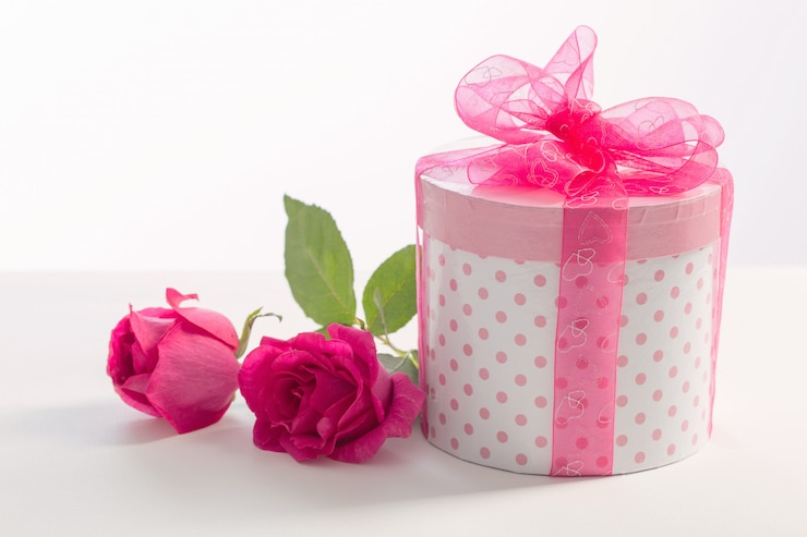 Photo coffret cadeau avec roses roses sur blanc