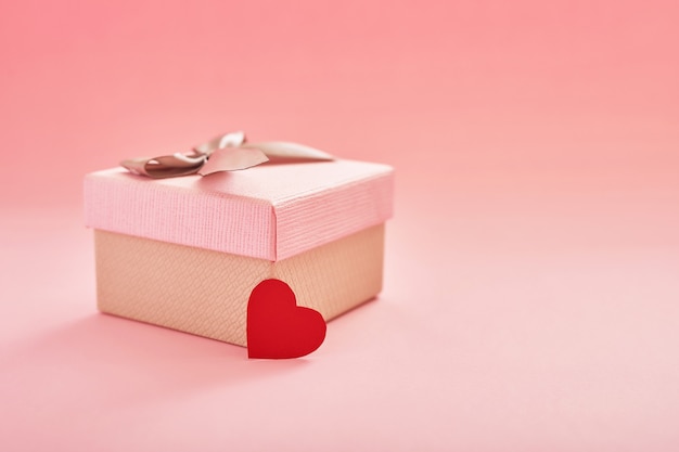 coffret cadeau sur une surface rose avec des coeurs pour la Saint Valentin