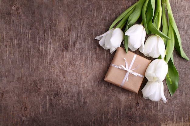 Coffret de fleurs (tulipes blanches) sur fond de bois rustique