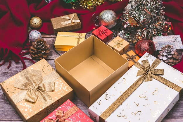 Un coffret ouvert et des décorations de Noël sur fond en bois.