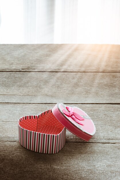 Coffret Saint Valentin sur de vieilles plaques en bois vintage en forme de coeur. Doux fond de vacances