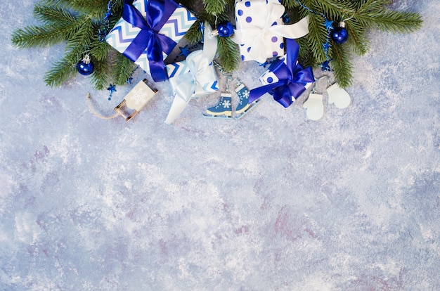 Coffrets cadeaux et branches de sapin avec décoration de couleur bleue.