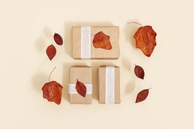 Coffrets cadeaux bricolage automne en papier kraft décoré de feuilles sèches rouges sur fond beige