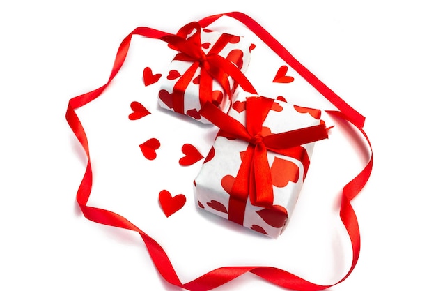 Coffrets cadeaux avec des coeurs rouges sur fond blanc. Le concept de cadeaux pour la Saint-Valentin. Concept de shopping, de vente et de remise.