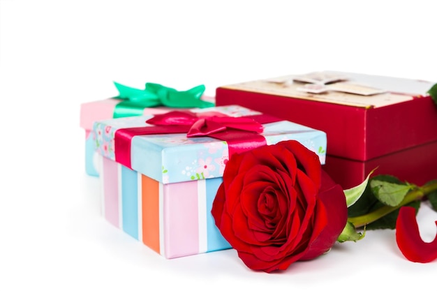 Coffrets cadeaux colorés et rose isolé sur fond blanc