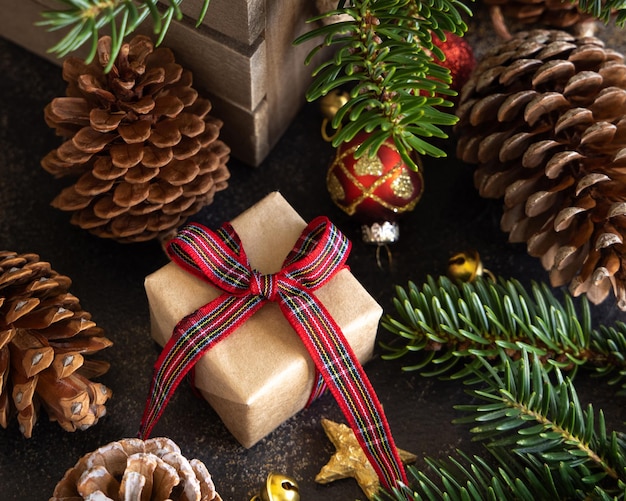 Coffrets cadeaux emballés entre les décorations de Noël des pommes de pin et des branches de sapin vert