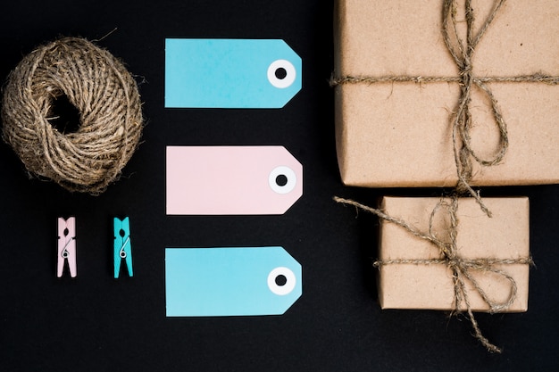 Photo coffrets cadeaux fabriqués à la main emballés dans du papier craft avec une étiquette de carte en papier bleu, une corde et des pinces à linge en bois pour la décoration.