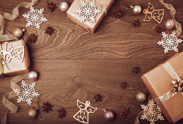 Coffrets cadeaux faits à la main de Noël décorés de branche de papier artisanal et de flocon de neige sur fond de bois