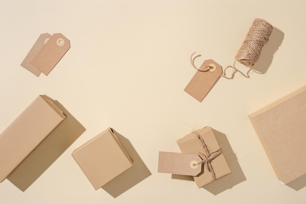 Coffrets cadeaux faits à la main à partir de papier kraft avec étiquettes sur fond beige Concept de vacances écologique