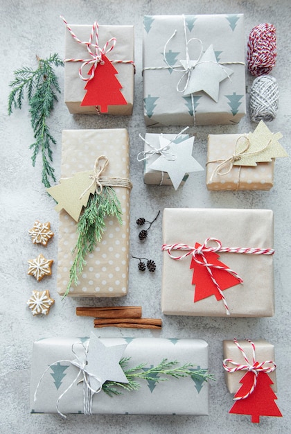 Coffrets cadeaux faits maison décoratifs de Noël enveloppés dans du papier kraft brun sur fond de béton gris